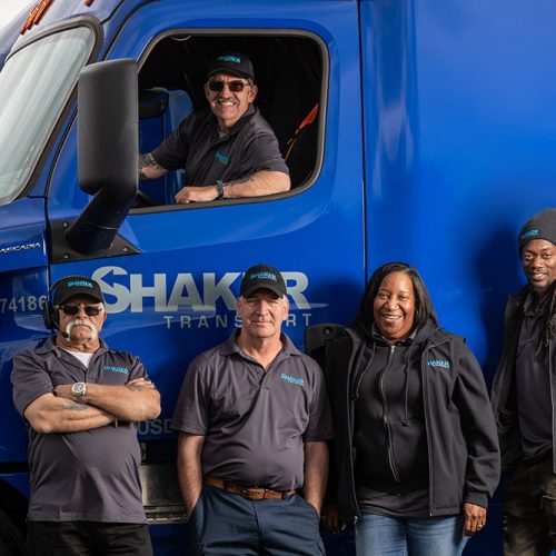 group of employees with one in cab of truck and rest standing in front