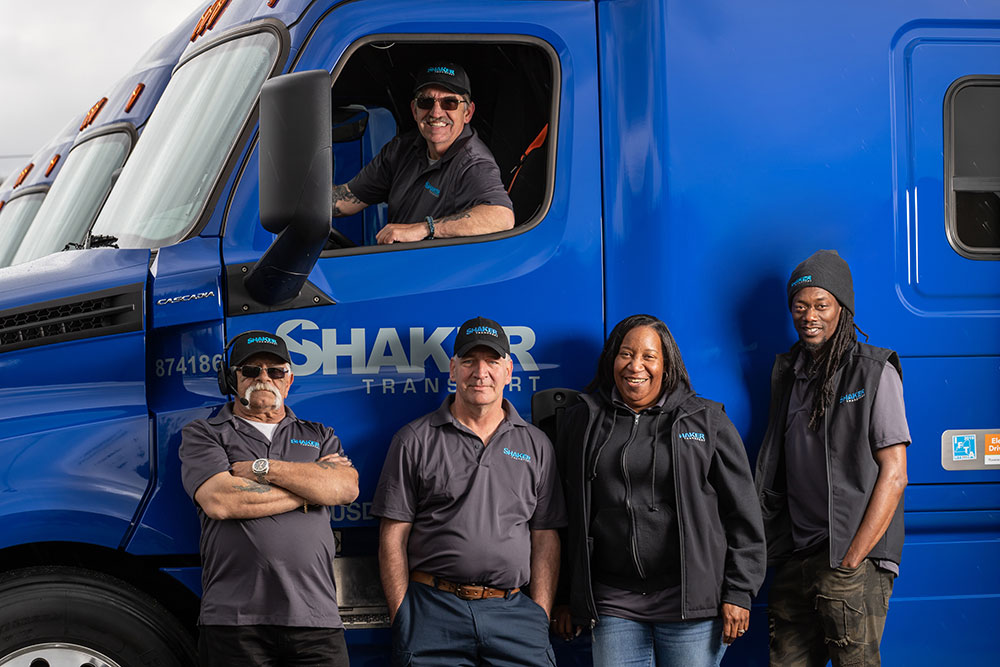 group of employees with one in cab of truck and rest standing in front